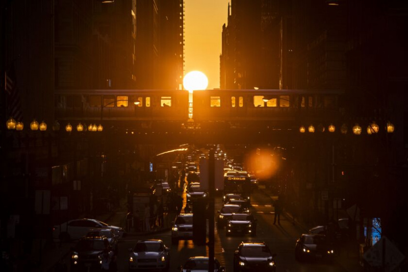   De zon staat bij zonsondergang op één lijn met de op het oosten en het westen gerichte straten van Chicago, ook wel bekend als het fenomeen 'Chicagohenge', gezien vanaf North Michigan Avenue in East Washington Street in the Loop op de avond van 20 maart 2021.