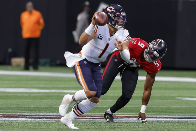   Een foto van Bears QB Justin Fields die tegen de Falcons wil gooien.