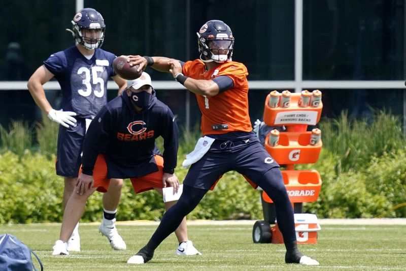 Le quart-arrière des Bears Justin Fields lance une passe lors des entraînements de l