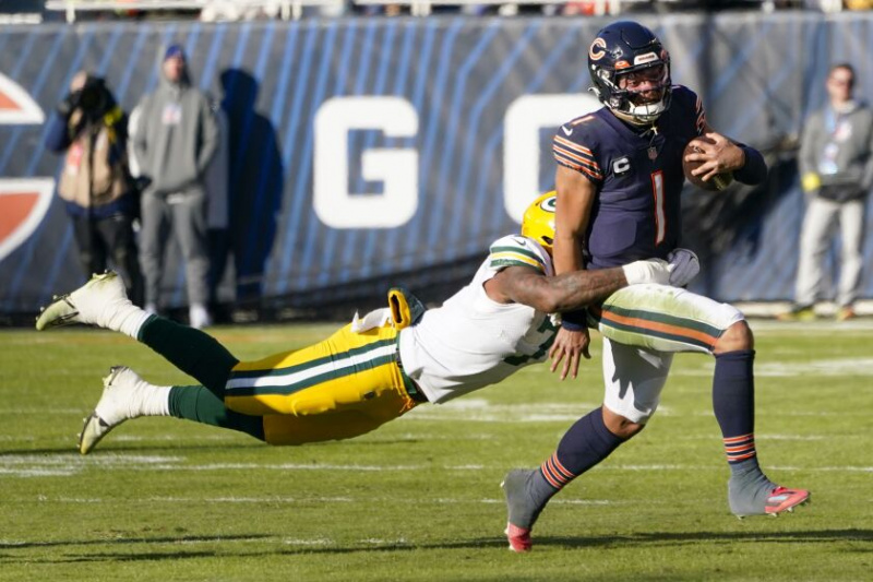  Medvěd quarterback Justin Fields běží s míčem proti Packers.