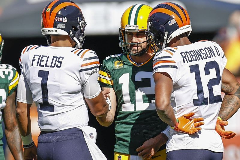 Justin Fields, a sinistra, chiacchiera con il quarterback dei Packers Aaron Rodgers all