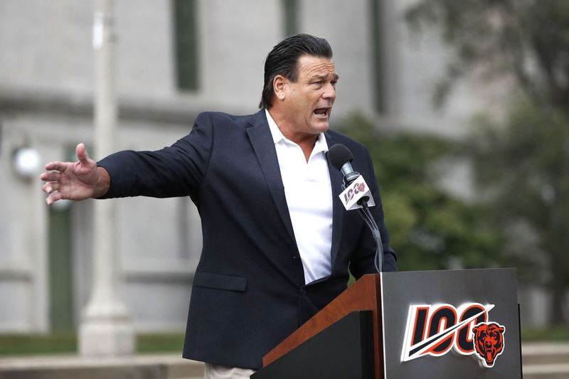 Bývalý tím Chicago Bears a profesionálna futbalová sieň slávy defenzívny zápas Dam Hampton, hovorí k davu počas odhaľovania sôch Georgea Halasa a Waltera Paytona v roku 2019 na Soldier Field.