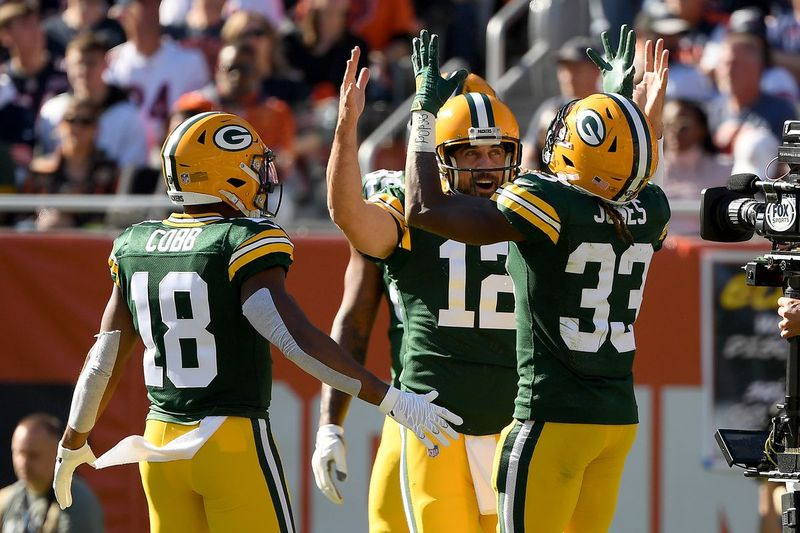 Aaron Rodgers (12) sărbătorește cu Randall Cobb (18) și Aaron Jones (33) după ce a marcat un touchdown în al patrulea sfert împotriva lui Bears.