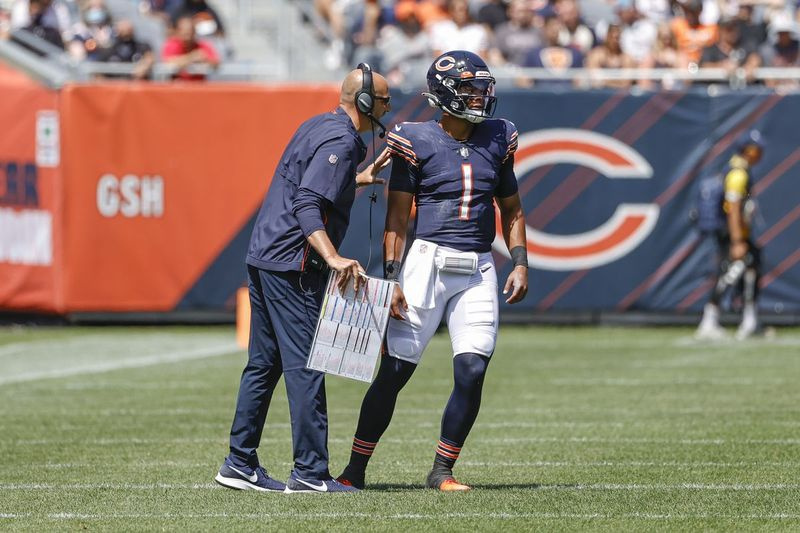 Rookie Justin Fields (1) heeft in zeven wedstrijden als beginnende quarterback een gestage verbetering laten zien onder de voogdij van coach Matt Nagy (links).