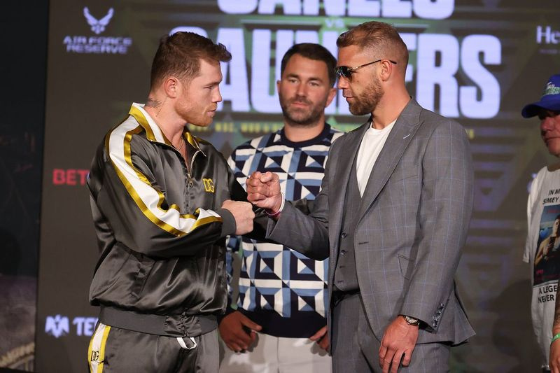 Canelo Alvarez et Billy Joe Saunders serrent la main du promoteur de Matchroom Eddie Hearn lors d