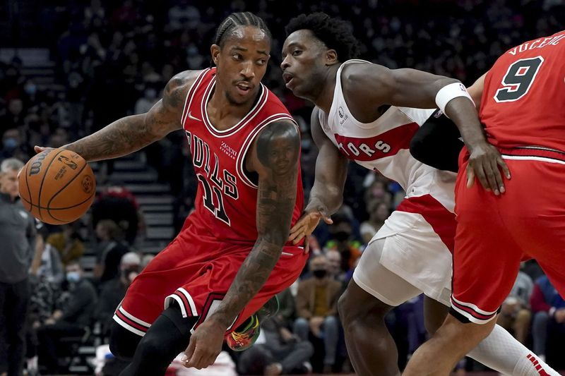 Bulls uzbrucējs Demars Derozans pārvietojas ap Toronto Raptors uzbrucēju OG Anunobiju.