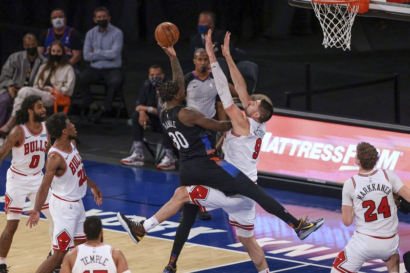 O atacante do Knicks Julius Randle (30) chuta contra o pivô do Bulls, Nikola Vucevic, na noite de quarta-feira. Randle marcou 34 pontos e levou os Knicks à vitória por 113 a 94 no Madison Square Garden.
