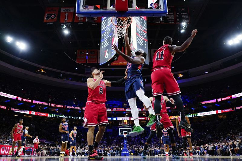 Joel Embiid des 76ers de Philadelphie se bat pour un dunk contre Nikola Vucevic des Bulls (à gauche) et DeMar DeRozan au cours de la seconde moitié du match de mercredi.