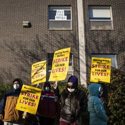 Un résident accroche une pancarte indiquant Pay The Pepole dans sa fenêtre au Ambassador Nursing & Rehabilitation Center à Albany Park alors que les travailleurs font grève lundi devant l