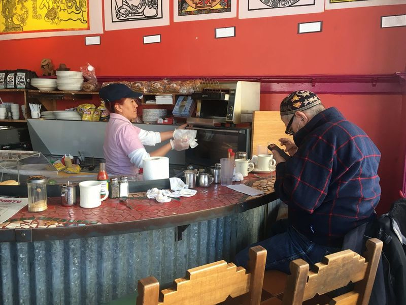 Bobby Davila folheia seu telefone no Café Jumping Bean em Pilsen na manhã de quarta-feira. | Carlos Ballesteros / Sun-Times