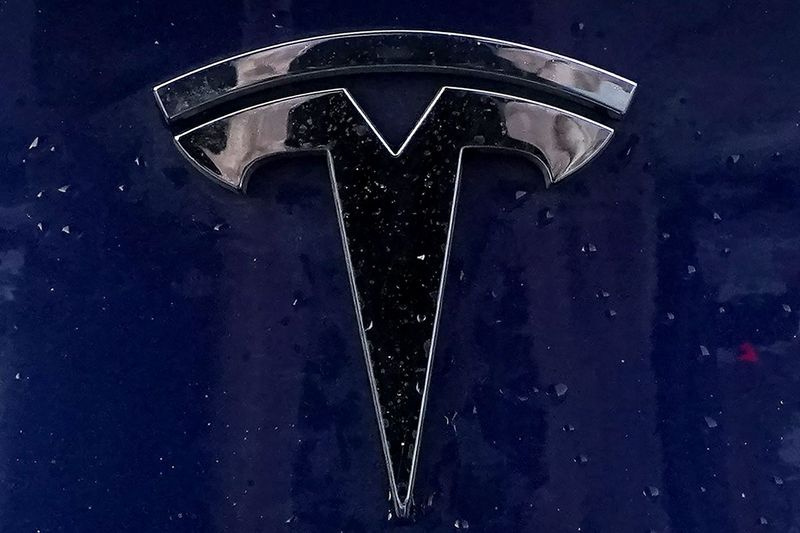 Na této souborové fotografii z 21. února 2021 je na osobním vozidle v Bostonu připevněn znak elektrického vozidla Tesla. Consumer Reports ve čtvrtek 22. dubna uvedl, že byl schopen snadno oklamat Teslu, aby řídila v režimu autopilota bez nikoho za volantem. Jeho test přišel jen několik dní poté, co Tesla havarovala v Texasu a zabila dva muže v autě. Podle úřadů ani jeden z mužů nebyl v době nehody na sedadle řidiče.