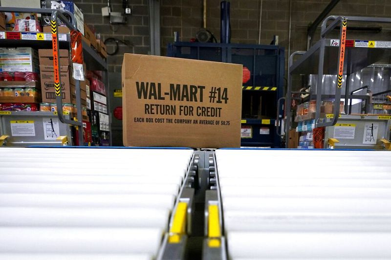 Una scatola di merce viene scaricata da un camion e inviata lungo un nastro trasportatore in un Walmart Supercenter a Houston.