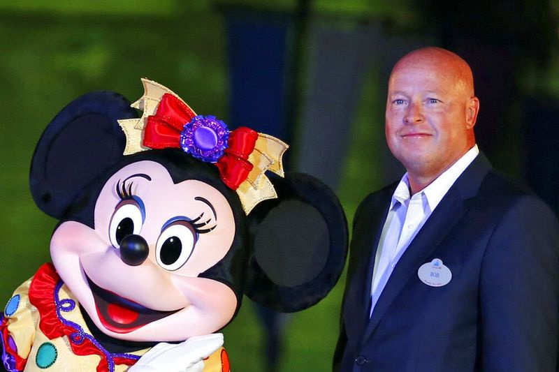 El presidente de Walt Disney Parks and Resorts, Bob Chapek, posa con Minnie Mouse durante una ceremonia en Hong Kong Disneyland.
