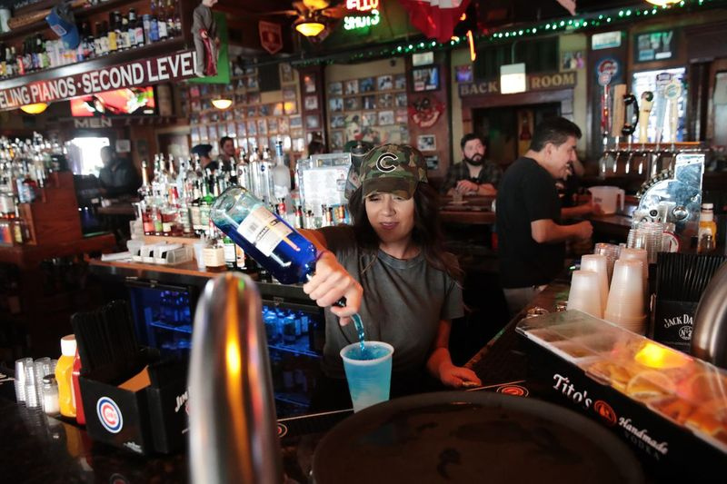 Bartender Ming Ling menunggu pelanggan di Sluggers, bar sukan dan gril milik keluarga di bawah bayang Wrigley Field, pada 15 Mac 2020.
