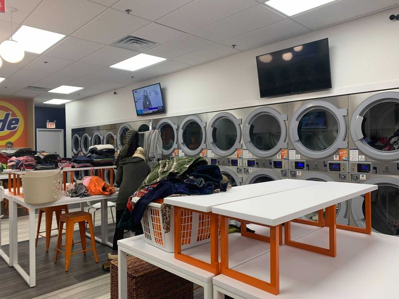 Skladacie stanice v Tide Laundromat sú rozmiestnené tak, aby umožňovali sociálne odstupy medzi používateľmi.