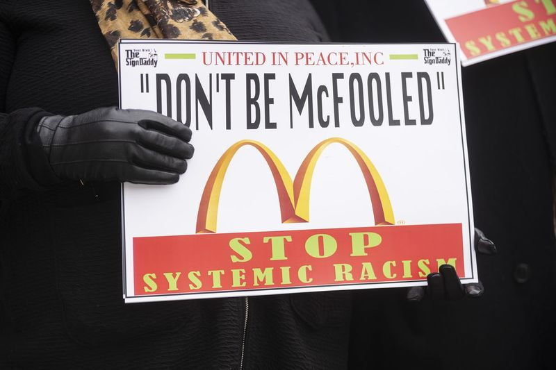Meeleavaldaja hoiab esmaspäeval, 22. veebruaril 2021 West Loopis McDonaldsi ülemaailmse peakorteri ees silti.
