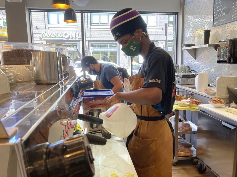 Davion Lyons face o băutură pentru un client la Cannelle by Matt Knio din Detroit. Afacerile din centrul orașului, cum ar fi Cannelle, care odinioară considerau de la sine înțeles o clientelă de angajați de birou, au fost nevoite să se adapteze, deoarece birourile rămân închise, iar lucrătorii rămân acasă.