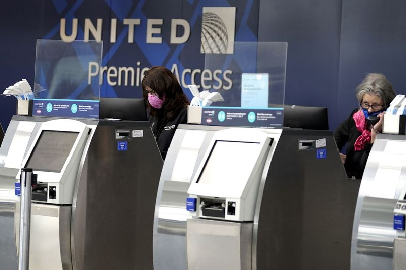 2020 m. spalio 14 d. „United Airlines“ darbuotojai dirba prie bilietų kasų O