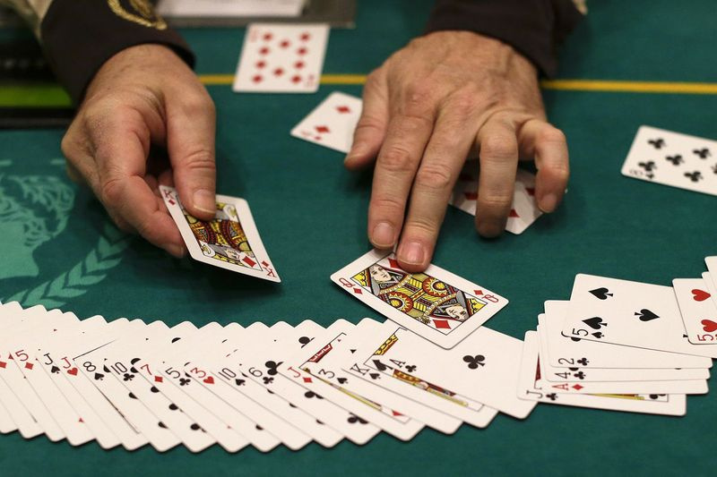 Un crupier reinicia una baraja de cartas durante una pausa en el juego de póquer en el Caesar
