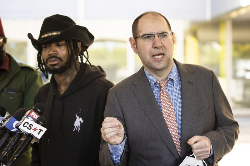 Adam Hollingsworth, 33, ook wel bekend als The Dread Head Cowboy, luistert terwijl zijn advocaat Jonathan Feldman de verslaggevers toespreekt na een hoorzitting bij de Circuit Court van Cook County op 727 E. 111th St. aan de Far South Side, woensdagochtend, september 30, 2020. Hollingsworth is aangeklaagd voor een misdrijf van verergerde dierenmishandeling voor het rijden op een paard op de Dan Ryan Expressway als een vorm van protest tegen kinderen die worden doodgeschoten in Chicago.