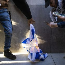 Sekumpulan kecil penunjuk perasaan cuba membakar bendera Israel ketika ribuan orang berhimpun menyokong Palestin dan berarak melalui Loop, petang Rabu, 12 Mei 2021.