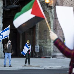 Dua penunjuk perasaan balas mengibarkan bendera Israel ketika ribuan orang berhimpun menyokong Palestin di Michigan Avenue berhampiran Grant Park, petang Rabu, 12 Mei 2021.