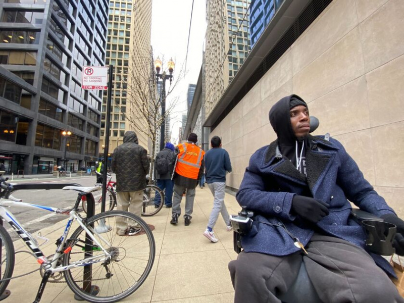   Nabi Yisrael, 48, sidder i sin kørestol uden for Morningstar, 22 W. Washington St., hvor handicappede og offentlige advokater samledes for at protestere mod en plan om at bygge et fodboldtræningsanlæg på en tidligere almen boliggrund på West Side. 