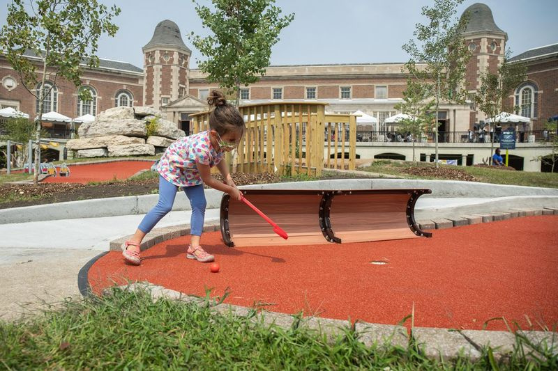 Virginia Hyatt juega al minigolf el día de la inauguración del campo de minigolf Douglass 18 en el vecindario de North Lawndale.