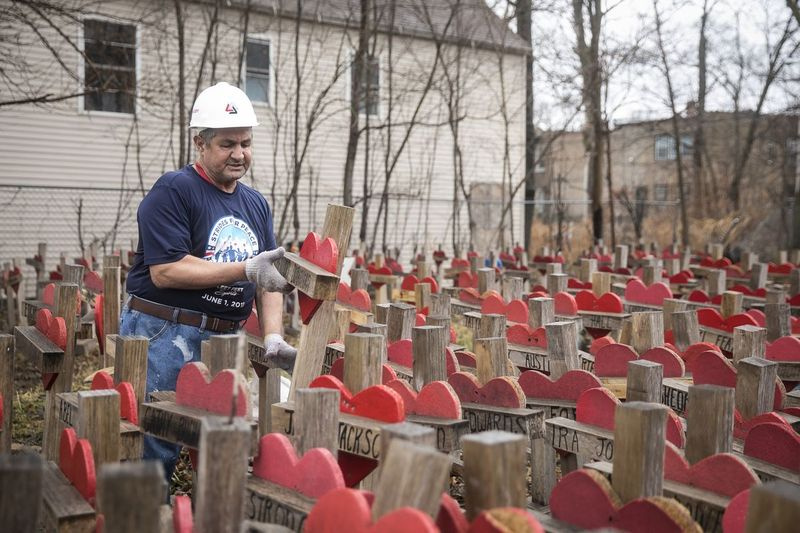 Greg Zanis, de Crosses for Losses, busca en unas 638 cruces de madera en honor a las víctimas de homicidio de Chicago que almacenó en un terreno baldío en Englewood. Era enero de 2018, y se estaba preparando para su reunión de América nunca olvidada: una cruzada para honrar a nuestros perdidos en Washington, DC, de familias que habían perdido a sus seres queridos a causa de la violencia armada, todas con sus cruces.