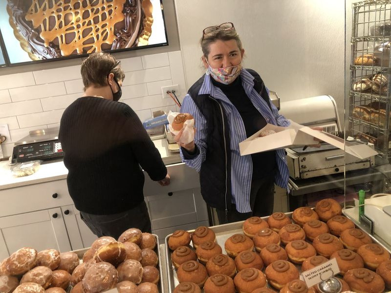 Dobra Bielinski, majiteľ Delightful Pastries, pomáha zákazníkovi vybrať paczki v utorok ráno.