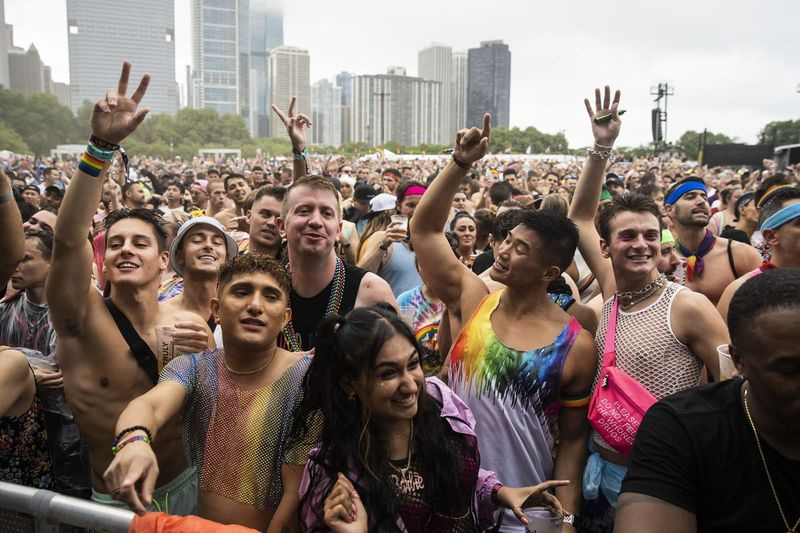 Pengunjung festival menari dalam hujan petang Sabtu semasa Pride in the Park di Grant Park.