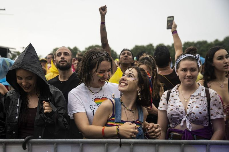 Zoe Meier, 19, dari Mount Prospect, menari dengan teman wanitanya, Stella Gross Shafer, 20, dalam hujan petang Sabtu semasa Pride in the Park di Grant Park.
