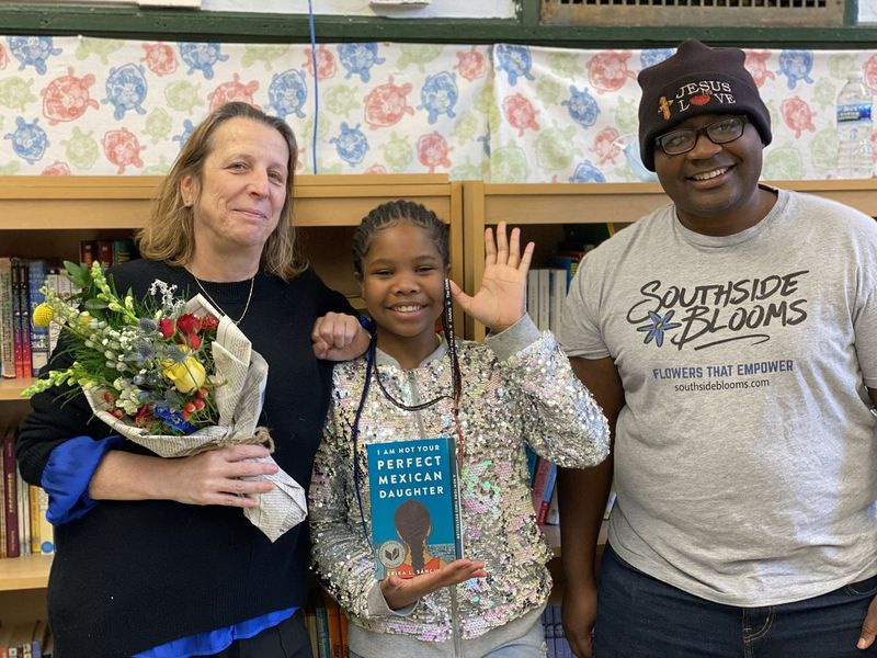 Kinadee Jordan, 13 ans, se tient aux côtés de la directrice exécutive de la Montessori School of Englewood, Rita Nolan, à gauche, et de la propriétaire de Southside Blooms, Quilen Blackwell, à droite, avec l