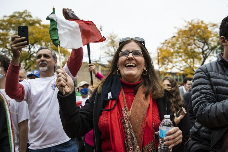 Beth Ann Iosco-Tarallo, 59 ans, de Melrose Park, agite un drapeau italien lors du Columbus Day : célébration du patrimoine italo-américain au parc Arrigo dans le quartier de Little Italy, lundi matin, 12 octobre 2020.