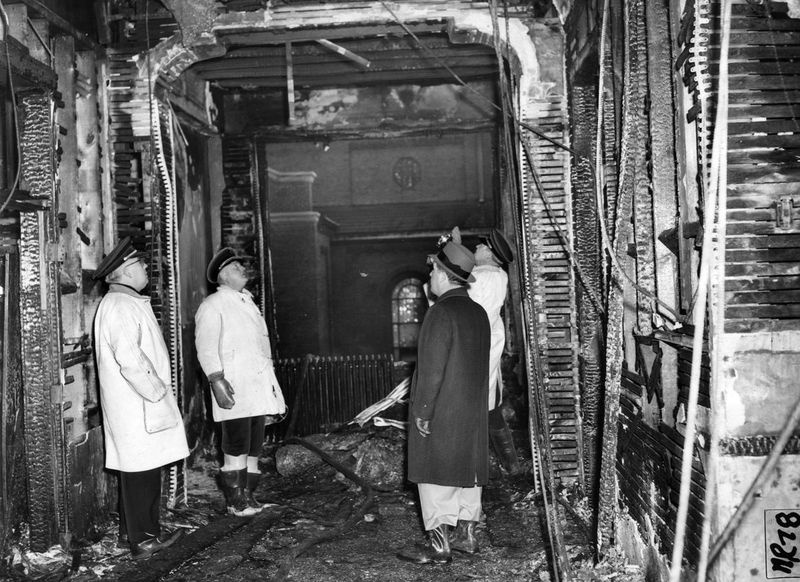 Des agents du Bureau de prévention des incendies inspectent le plafond du couloir du troisième étage à l