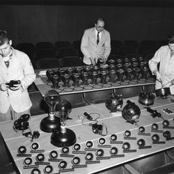 Três técnicos com peças de projetor Zeiss em 1955.