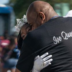 Bud Billiken Koningin Kennedi Eggleston omhelst haar vader tijdens de jaarlijkse back-to-school parade.