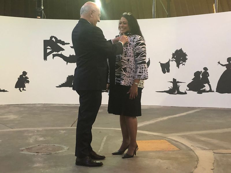 Philippe Etienne, Frankrigs ambassadør i USA, fastgør The Order of Arts and Letters-medaljen, den franske regerings højeste udmærkelse inden for kunst, til præsidenten og administrerende direktøren for DuSable Museum of African American History, Perri Irmer, ved en ceremoni mandag aften.