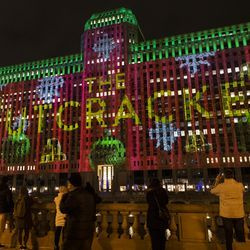 Setki ludzi gromadzą się przed Merchandise Mart na chicagowskim Riverwalk, aby obejrzeć inaugurację Art on the Mart ze specjalną prezentacją tematyczną „Dziadek do orzechów” z Joffrey Ballet, czwartek, 13 listopada 2020 r.