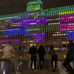 Setki ludzi gromadzą się przed Merchandise Mart na chicagowskim Riverwalk, aby obejrzeć inaugurację Art on the Mart ze specjalną prezentacją tematyczną „Dziadek do orzechów” z Joffrey Ballet, czwartek, 13 listopada 2020 r.