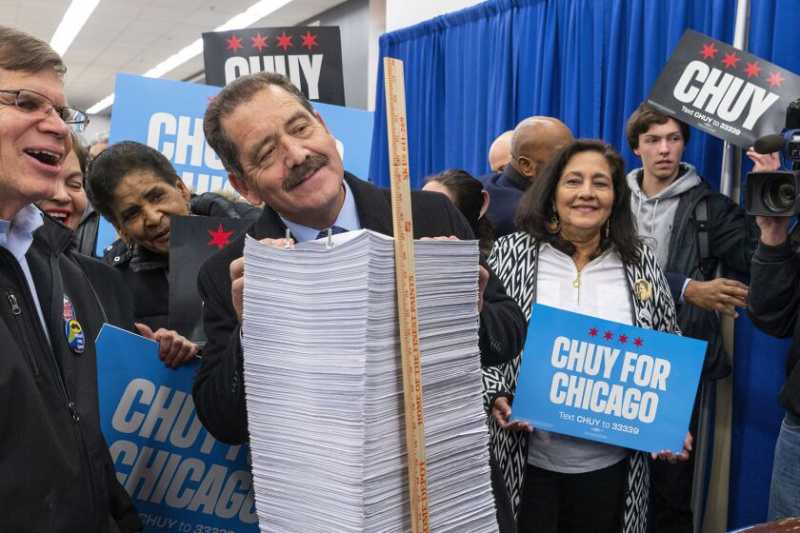   Den amerikanska representanten Jesus 'Chuy' Garcia ser höjden av sin hög med nomineringsframställningar på styrelsen för valkommissionärers supersite, måndag eftermiddag.