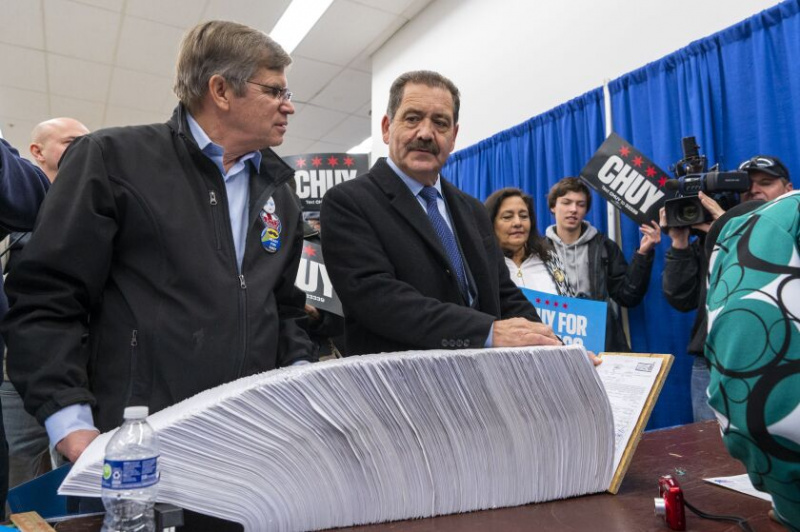   USA:s representant Jesus 'Chuy' Garcia, höger, och hans politiska rådgivare Clem Balanoff tittar på när Garcias nomineringsframställningar för att få hans namn på valsedeln som kandidat till borgmästarkandidat i Chicago behandlas av valstyrelsens tjänstemän måndag eftermiddag.