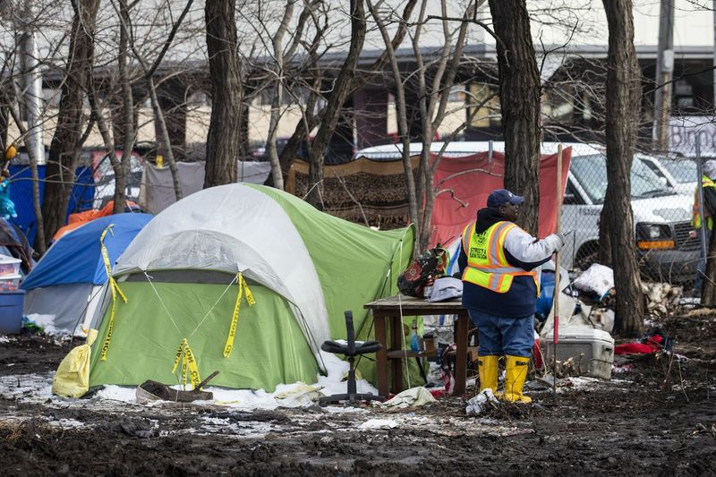 I lavoratori del Department of Streets and Sanitation della città sgombrano un accampamento di senzatetto vicino a South Desplaines Street e West Roosevelt Road.