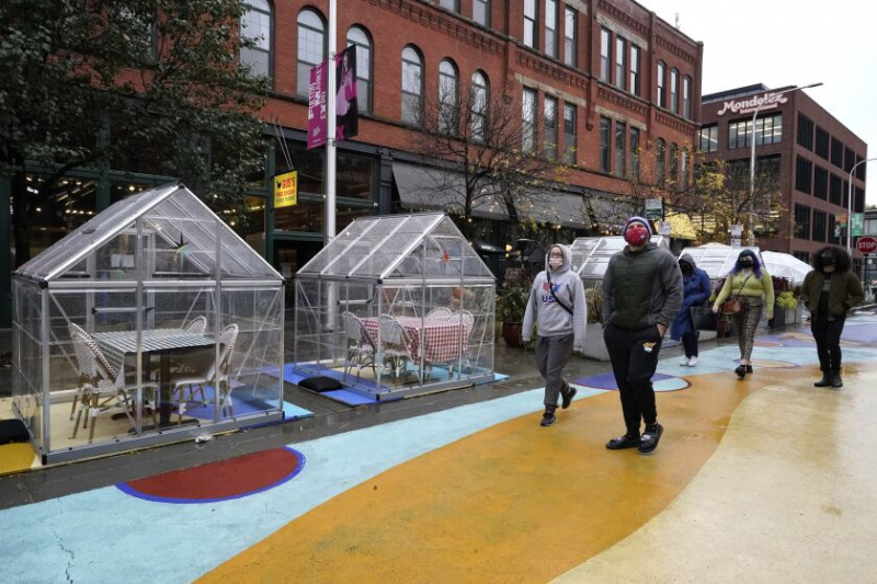   Ľudia chodia okolo vonkajších plastových jedálenských bublín na Fulton Market v Chicagu v októbri 2020.