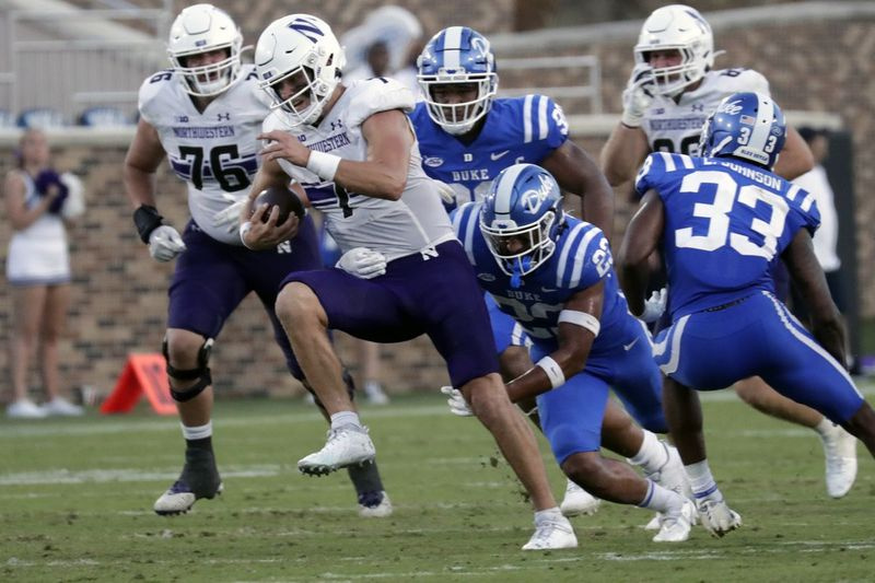 Northwestern quarterback Andrew Marty (7) ontwijkt Duke veiligheid Lummie Young IV (23) tijdens de tweede helft van een wedstrijd op 18 september.