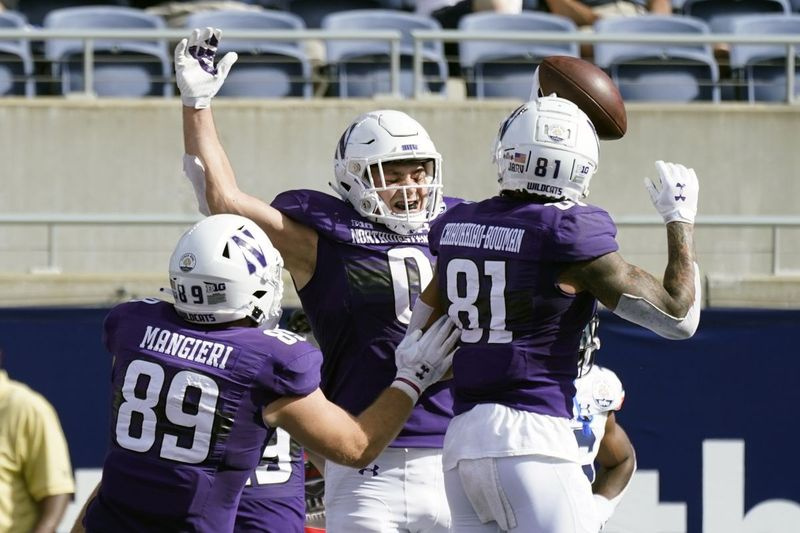 Northwestern tight end John Raine (0) świętuje przyjęcie przyziemienia przeciwko Auburn z kolegami z drużyny Charlie Mangieri (89) i Ramaud Chiaokhiao-Bowman (81) podczas pierwszej połowy Citrus Bowl.