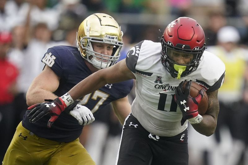 Leonard Taylor (11) z Cincinnati je pronásledován JD Bertrandem (27) z Notre Dame během druhé poloviny vítězství Bearcats nad Fighting Irish.