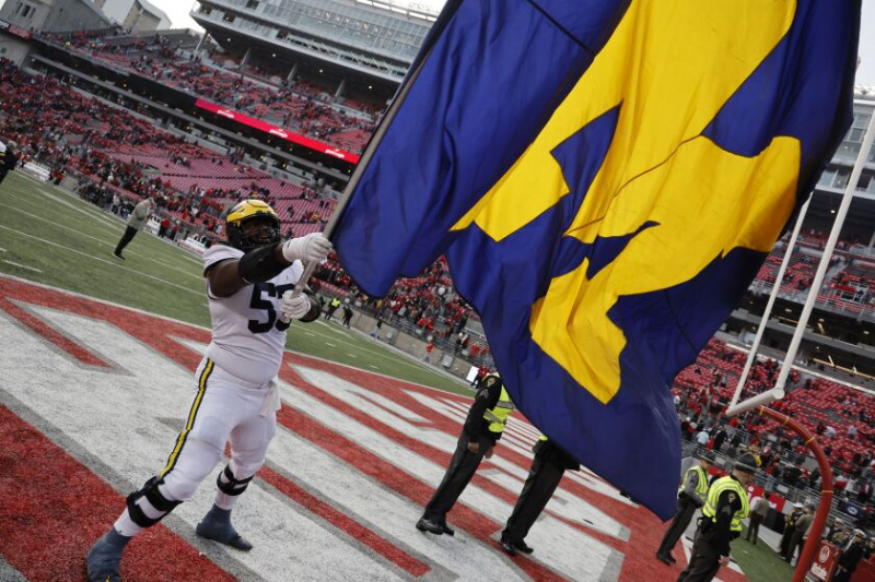   El liniero ofensivo de Michigan, Trente Jones, ondea la bandera del equipo para celebrar la victoria del sábado sobre Ohio State.