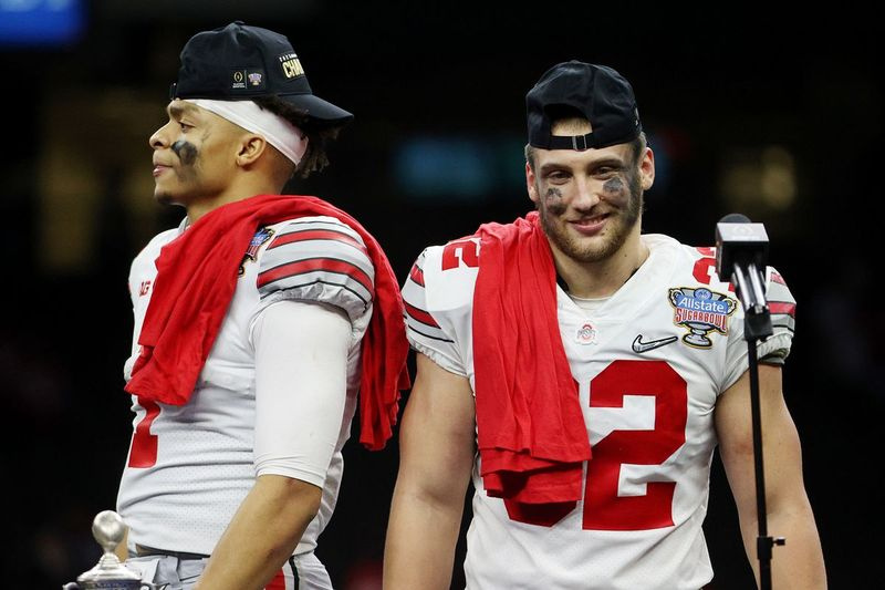Justin Fields # 1 y Tuf Borland # 32 de los Ohio State Buckeyes reaccionan después del juego contra los Clemson Tigers durante la semifinal de la eliminatoria de fútbol americano universitario en el Allstate Sugar Bowl en el Mercedes-Benz Superdome el 1 de enero de 2021 en Nueva Orleans, Luisiana.