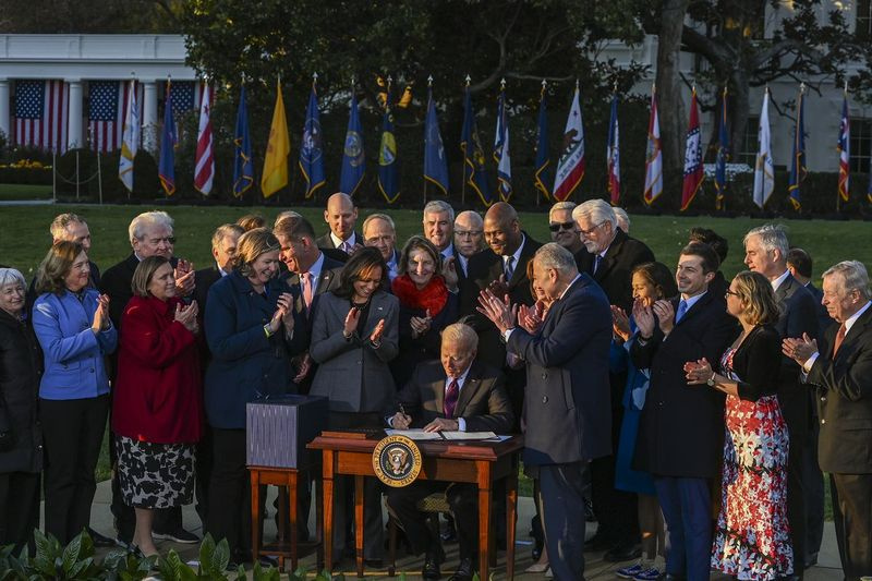 Præsident Joe Biden underskriver loven om infrastrukturinvesteringer og job, da han er omgivet af lovgivere og medlemmer af sit kabinet under en ceremoni på South Lawn i Det Hvide Hus mandag den 15. november 2021.